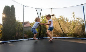 two babies jumping on trampoline