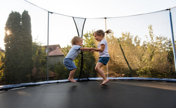 two babies jumping on trampoline