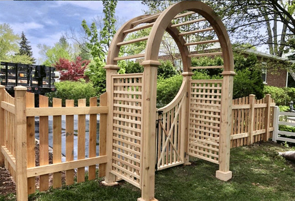 Cedar picket fence with an arched Nantucket arbor and lattice walk gate in a front yard