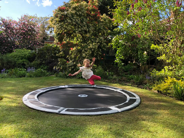 Girl Jumping on In Ground Trampoline