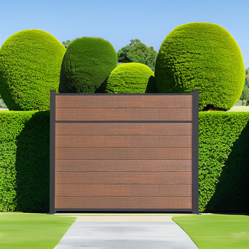 Dark brown horizontal slat composite fence panel between two manicured topiary shrubs