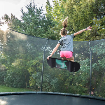 Person on a trampoline with a skateboard