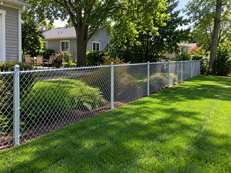 Galvanized chainlink fence along a suburban back yard