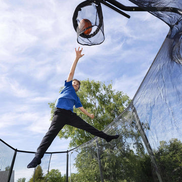 Child playing basketball on a trampoline 